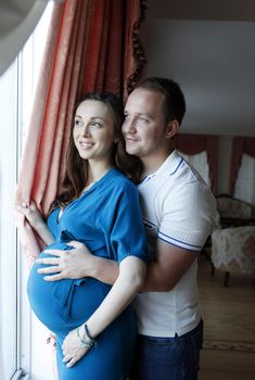 Happy beautiful pregnant woman with his husband at home