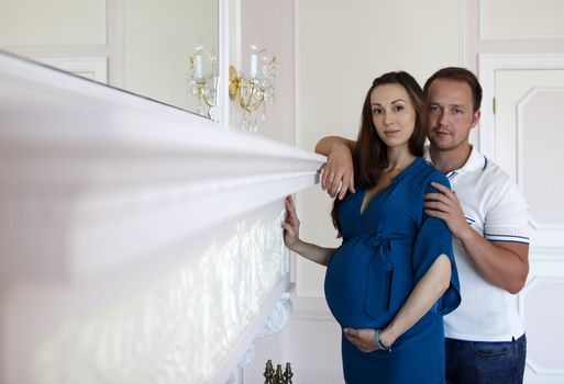 Happy beautiful pregnant woman with his husband at home