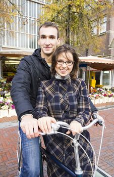 Happy young couple with bicycle near the flower market