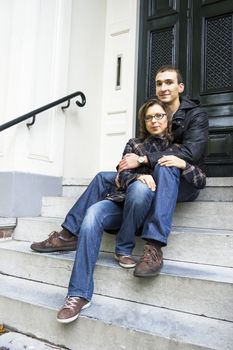 Portrait of love couple sitting on traditional Dutch porch looking happy