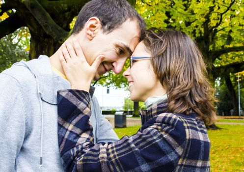 Portrait of love couple embracing outdoor looking happy