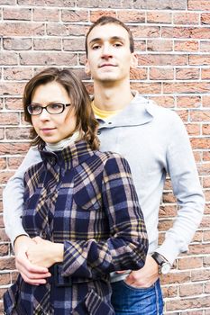 Portrait of love couple embracing looking happy against wall background