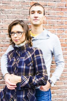 Portrait of love couple embracing looking happy against wall background