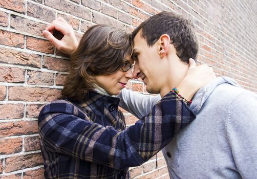 Portrait of love couple outdoor looking happy against wall background