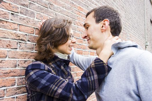 Portrait of love couple outdoor looking happy against wall background