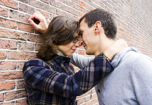 Portrait of love couple outdoor looking happy against wall background