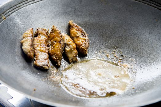 Fried pieces of fish in a pan