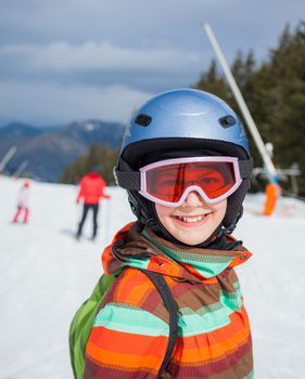 Portrait of girl in helmet and ski goggles on a sunny day in the mountains