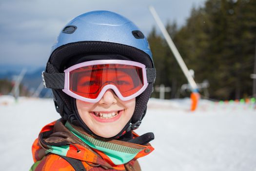 Portrait of girl in helmet and ski goggles on a sunny day in the mountains