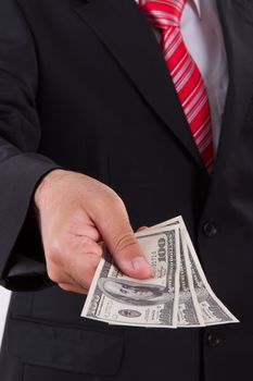 Businessman with dark jacket and red tie giving bills, one hundred dollars money.