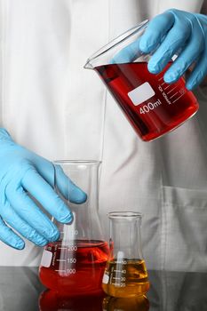 Laboratory Glassware with fluids and gloved hands