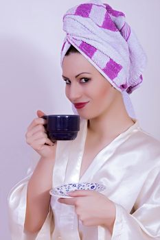 portrait of woman with towel on her head drinking coffee