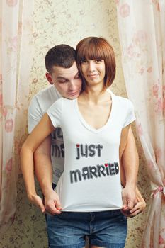 Happy newlyweds hugging T-shirts, shot in the studio