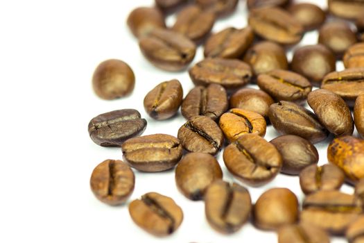 PIle of fine selected roasted coffee beans on white background. Shallow depth of field