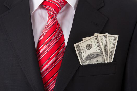 Smart businessman with earned money in suit pocket.
