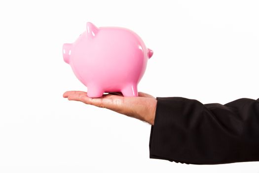 Businessman holding pink piggy bank, isolated on white background.