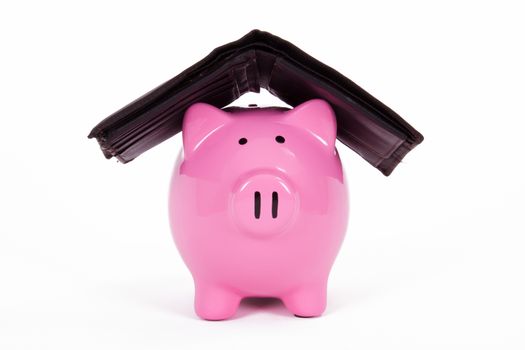 Pink piggy bank protected by dark wallet, isolated on white background.