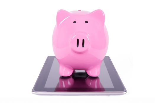 Pink piggy bank on tablet with blank screen, isolated on white background.