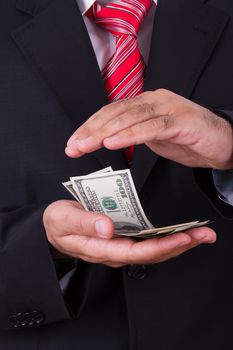 Businessman protecting, saving money between two hands.