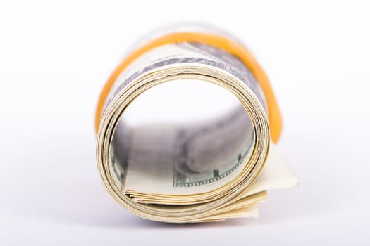 Roll of one hundred dollar banknotes, isolated on white background.