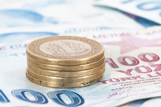 Turkish lira coins in a row on hundred banknotes.