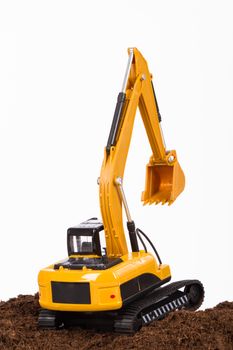 Construction machine, excavator on pile of soil digging a trench, isolated on white background.