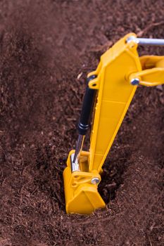 Construction machine, excavator on pile of soil digging a trench.