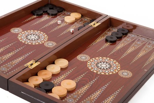 Backgammon table, chips and dices during the game, isolated on white background.