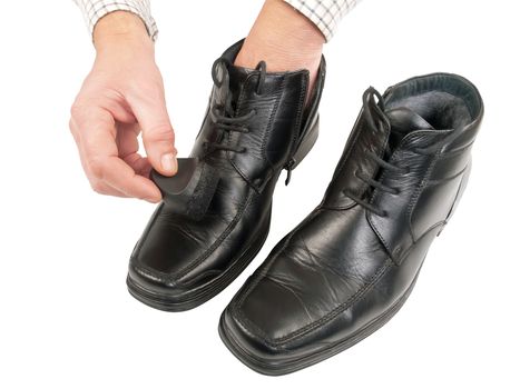 man polishing black shoes, isolated on white background, studio shot