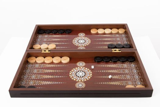 Backgammon set with table, chips and dice at the beginning, isolated on white background.