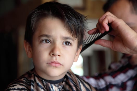 Male child at the barber shop to cut the hair