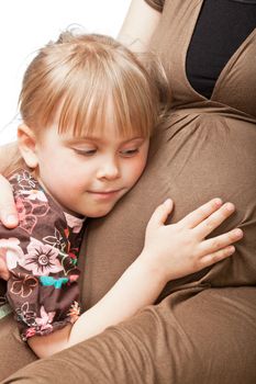 Little girl embracing pregnant mother