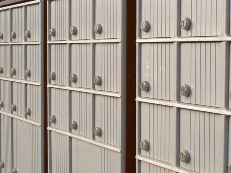 Rows of receding lockers with metal doors and locks of outdoor silver canadian mailboxes for safe delivery of rural mail post