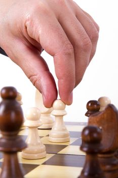 Businessman playing chess and holding pawn, isolated on white background.