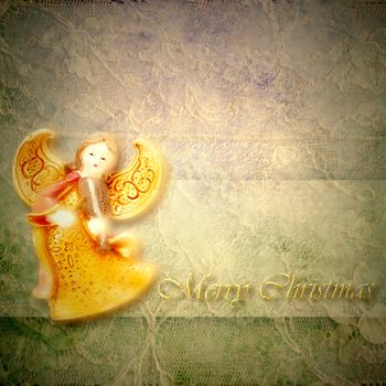 Angel musician on lace background with merry christmas text in gold letters