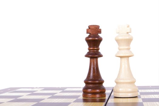 Confrontation of chess pieces kings on board with space, isolated on white background.