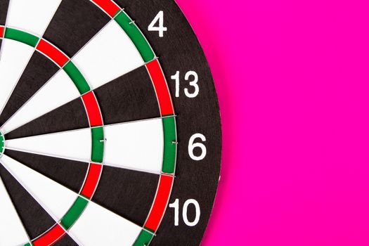 Dart board with black and white sections on pink background.