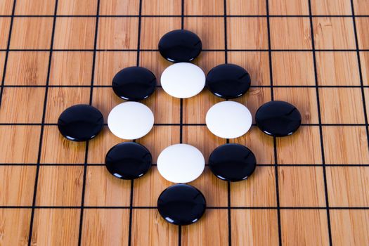 Close up view of black and white pieces on Chinese go game board.