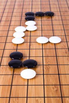 Close up view of black and white stone pieces on Chinese go game board.