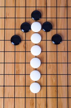 Top view of black and white Chinese go game pieces, up direction arrow shape.