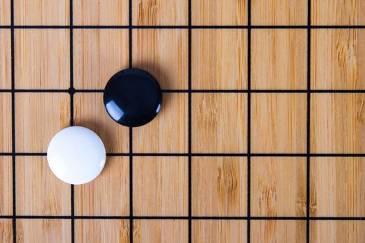Close up view of black and white stone pieces on Chinese go game board.