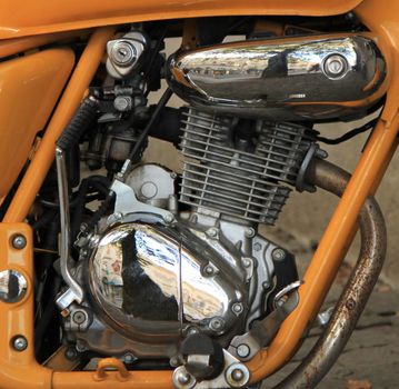 Motorcycle engine close up with orange frame and rustiness