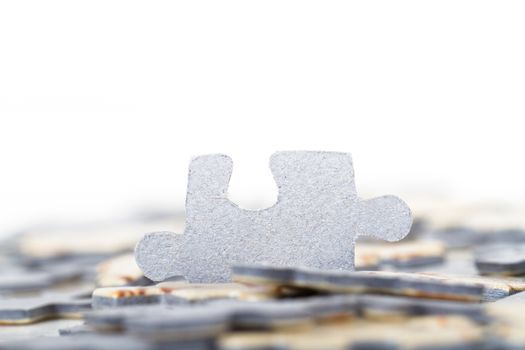 Small puzzle piece standing out among others, isolated on white background.