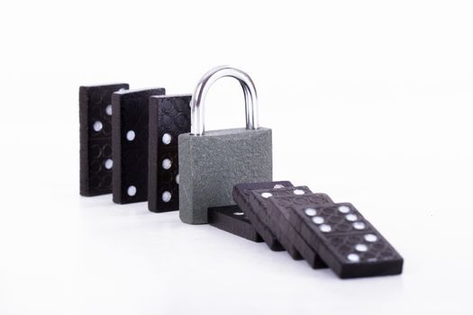 Damage control of black dominoes with padlock for security, isolated on white background.