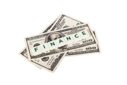 Finance word in letters and one hundred dollar bills, isolated on white background.