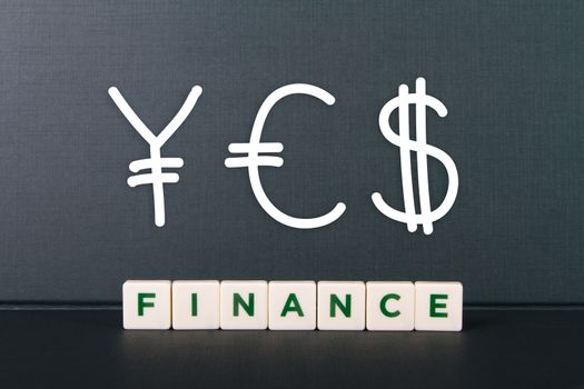 Finance word in letters and  financial symbols like yen, euro and dollar.