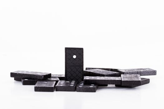 Leadership concept, domino standing out from the crowd, isolated on white background.