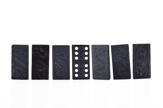 Black dominoes in a row, isolated on white background.