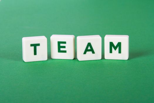 Team word in letters on green background.