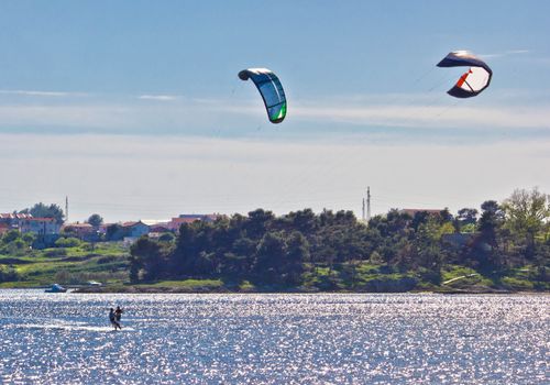 Pair of kitesurfers kitesurfing on the sea